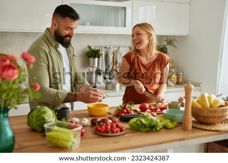 Affectionate couple cutting vegetable in the kitchen