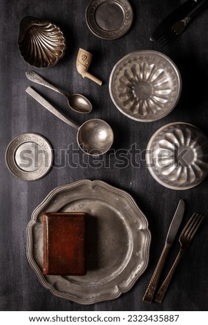 Various antique vintage dishes on black chalkboard background. Flat lay. Top view. Food concept. Dark mood food photography.