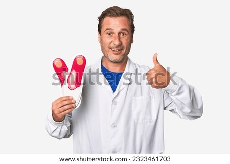 A middle-aged podiatrist holding an insoles Royalty-Free Stock Photo #2323461703