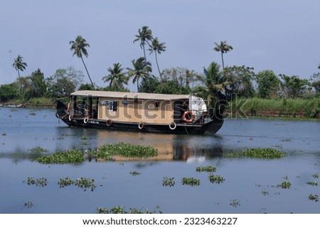 A houseboat sailing in Alappuzha backwaters in Kerala state in India. Travel tourism background - panorama of tourist houseboat on Kerala backwaters.