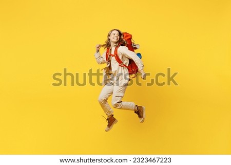 Full body young woman carry bag with stuff mat jump high look aside on area isolated on plain yellow background. Tourist leads active lifestyle walk on spare time. Hiking trek rest travel trip concept Royalty-Free Stock Photo #2323467223
