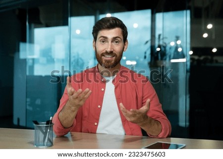 Mature man in shirt smiling and looking at camera, video call online meeting, webcam view, pov, worker at workplace inside office. Royalty-Free Stock Photo #2323475603