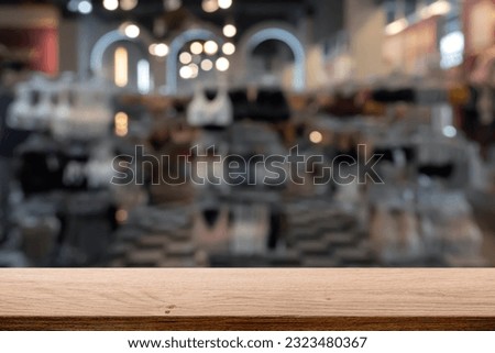Empty wooden table space platform and blurred cloth store or fashion shop for product display montage.