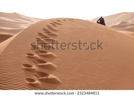 A person walking through the Erg Chebbi desert in the African Sahara, Morocco Royalty-Free Stock Photo #2323484811