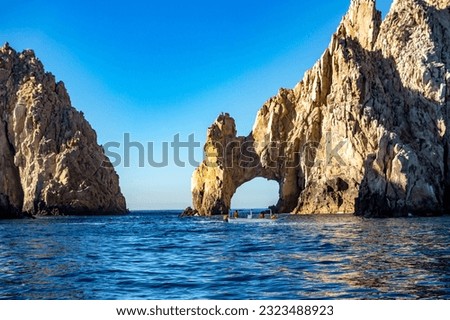 Tourists in the arch of Cabo San Lucas sailing the Gulf of California that joins the sea of cuts with the Pacific Ocean at the end of the land in Baja California Sur. Beach concept in Mexico.