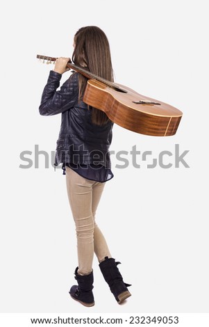 Full length portrait of  teenage girl with a guitar on her shoulder, back view, over white background 