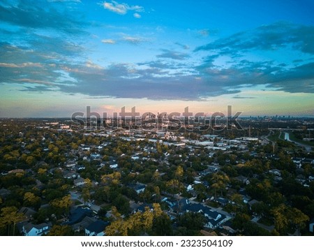 A horizontal aerial view of Houston, Texas skyline from a suburban neighborhood under blue sky