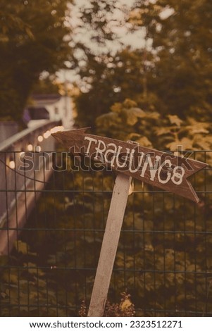 A vertical shot of wooden sign with arrow with german "Trauung" - wedding text