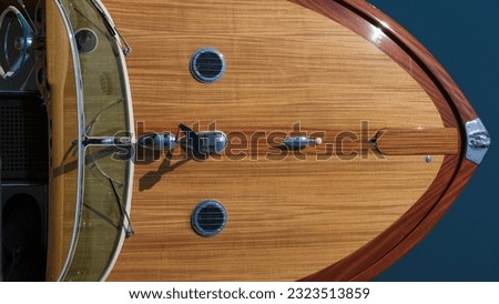 Fore deck. Wooden deck on a blue background top view. The front of a wooden boat on a blue background top view. Expensive wooden lacquered part of the boat. Royalty-Free Stock Photo #2323513859