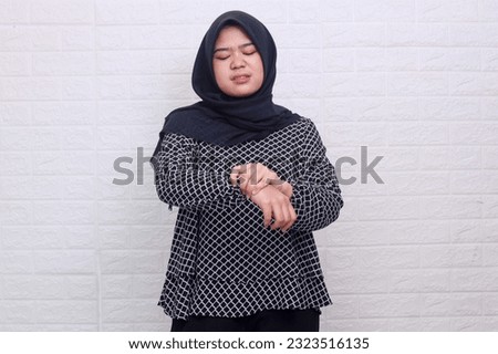 Young muslim woman suffering from wrist pain, numbness, or Carpal tunnel syndrome hand holding her ache joint