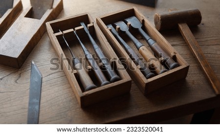 Japanese chisel set and other cutting tools on old rustic desk.  Royalty-Free Stock Photo #2323520041