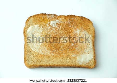 Top view of whole wheat piece of buttered toast isolated on white