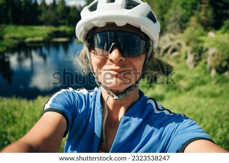 Happy cyclist taking selfie in front of nature. High quality photo