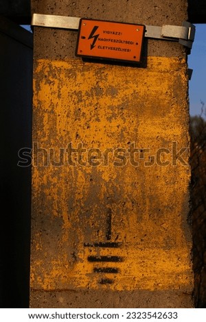 A vertical shot of a danger sign on the rusty wall