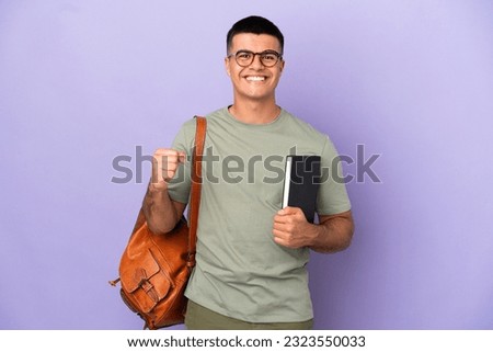 Handsome student man over isolated background celebrating a victory in winner position Royalty-Free Stock Photo #2323550033