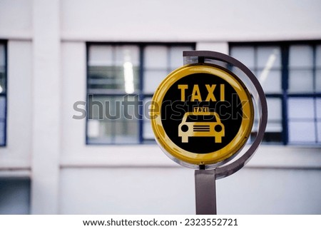 A yellow taxi sign illuminated in front of an office building