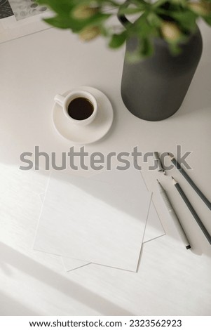Blank paper mockups, tools for sketching, cup of coffee, modern ceramic vase  on white background. The artist's work in process concept.