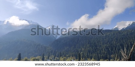 Gulmarg Srinagar, Jammu and Kashmir, India. Himalayan landscape with peaks covered in snow and clouds with visible blue scenic sky. 