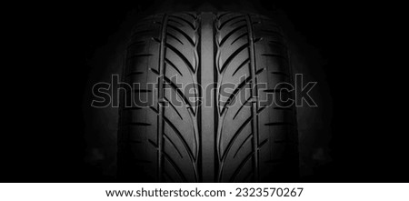 Car tire tread. Car tire tread close up. Studio shot on dark background. Royalty-Free Stock Photo #2323570267
