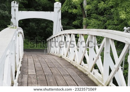 Many people walk across this footbridge in Lenape Park. Royalty-Free Stock Photo #2323571069