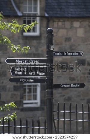 A vertical shot of a streets sign column leading to different locations