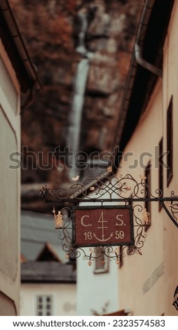 A vertical shot of a Hanging Sign on a Building in Hallstatt in Austria