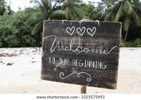 A beautiful shot of a welcome to our beginning wooden sign at the coast of La Digue island