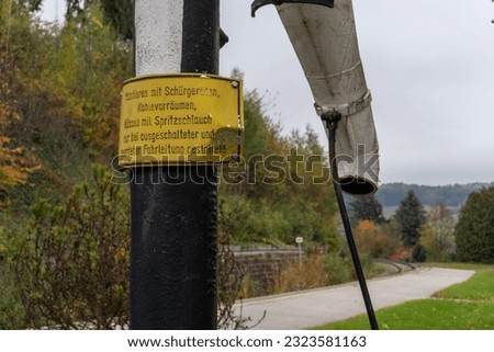 A warning sign on a post near the road