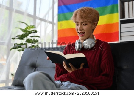 Portrait with Young Asian gay teenager enjoying with a book, Reading a book while sitting on the sofa at home, Taking advantage of free time concept.