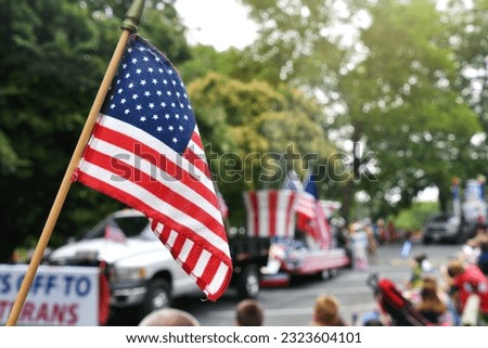 Waving an American flag at the Independence Day Parade on the 4th of July Royalty-Free Stock Photo #2323604101