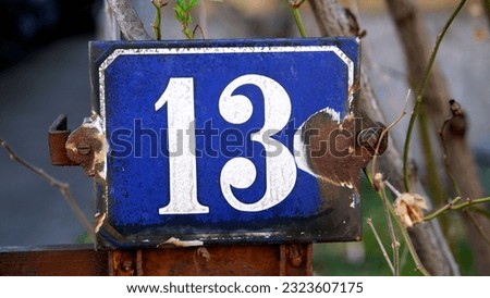 A closeup of sign number thirteen in blue and white outdoors