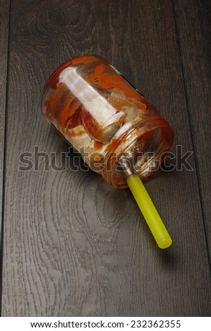 Empty ketchup jar on the floor vertical photo