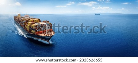 Panoramic front view of a large cargo ship carrying containers for import and export, business logistic and transportation in open sea with copy space  Royalty-Free Stock Photo #2323626655