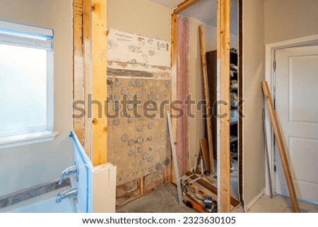 A walk-in shower remodel under construction. Framed with subfloor, curb, drain, cement board, show pan and membrane added before tiling, in a residential bathroom. Royalty-Free Stock Photo #2323630105