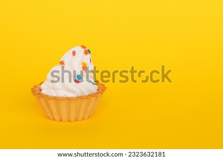 The basket cake is decorated with colorful edible decorations, and is photographed against a yellow background.