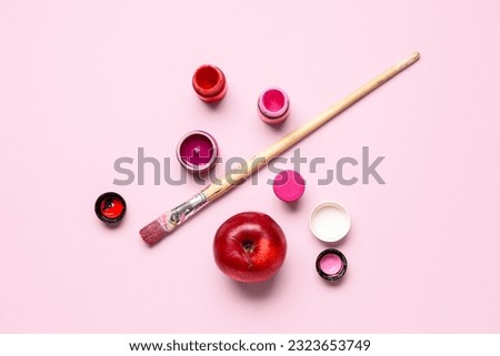 Brush, bottles with different shades of pink paint and apple on color background Royalty-Free Stock Photo #2323653749
