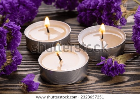 Candle. Tea Lights Candle. Mini Tealight candles for home decoration. Flowers on wooden table. Dripless and long lasting paraffin or white beeswax. Good for essential oil diffuser or aroma lamps. Royalty-Free Stock Photo #2323657251