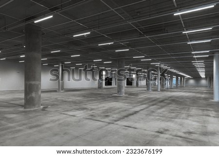 Abstract empty parking interior with concrete pillars and neon lights, modern architecture background photo
