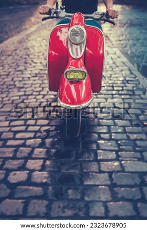 A Man Riding A Scooter Or Moped Down A Cobbled Street In Rome, Italy Royalty-Free Stock Photo #2323678905