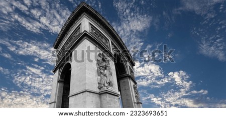 Arc de Triomphe (against the background of sky with clouds), Paris, France. The walls of the arch are engraved with the names of 128 battles and names of 660 French military leaders (in French) 