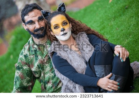 Young couple wearing wolf and woodcutter costumes. Real family having fun while using costumes of the Little red riding hood tale in Halloween.