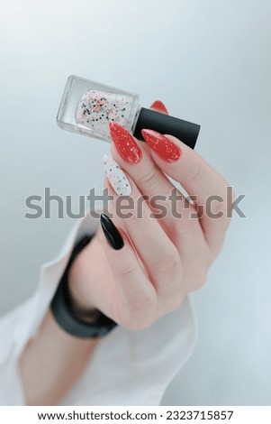 Female hands with long nails and bright red and white manicure