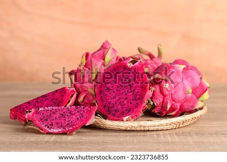 Red dragon fruit or pitaya in basket on wooden background, Tropical fruit in summer season