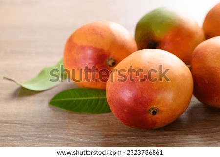 Ripe Mango fruit (Tommy Atkins) on wooden background, Tropical fruit Royalty-Free Stock Photo #2323736861