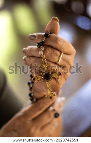 hands of a woman wearing a wedding ring holding a rosary with a lot of faith