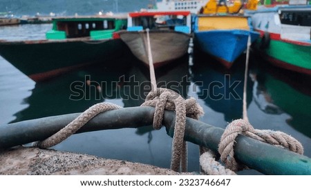 The traditional passenger boat rope crossing to Lembeh Island is anchored at the pier Royalty-Free Stock Photo #2323746647