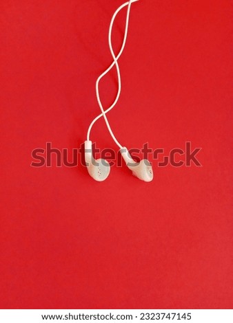 white earphones on a red background