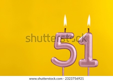Birthday candle number 51 - Birthday celebration on yellow background Royalty-Free Stock Photo #2323756921
