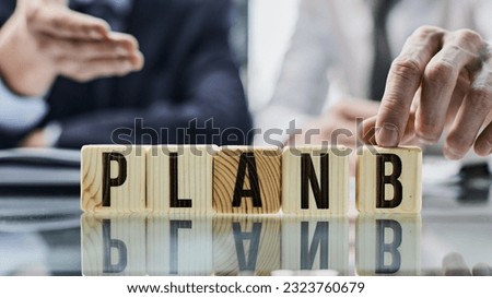 businessman folded the word Plan B from puzzles on the table.
