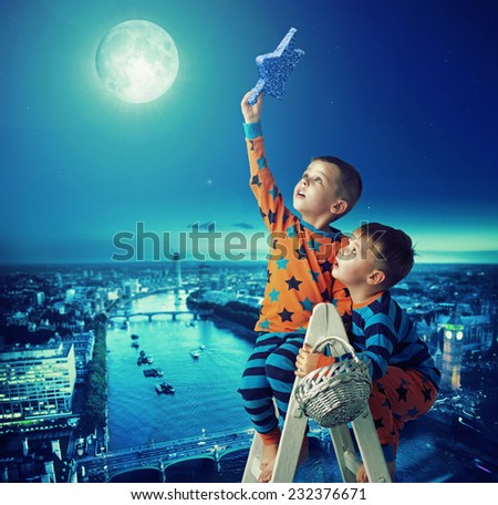 Young brothers reaching stars Royalty-Free Stock Photo #232376671